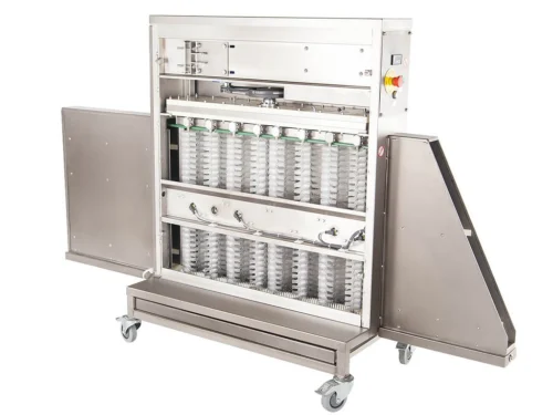 Universal tray cleaning machine with open compartments showing multiple rows of capsule slots, set on a wheeled base, made of stainless steel.